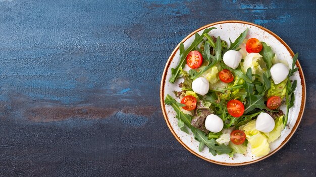 Dieetsalade met verse groenten van rucola en kaas op een plaat