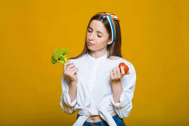 Dieetvoeding Mooie vrouw met biologische groene broccoli Portret van lachend meisje