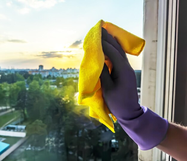 Dien handschoen schoonmakend vensterglas met wisser afvegende doek in