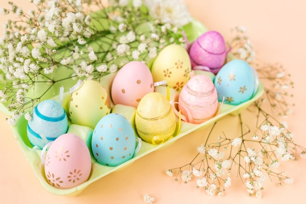 Dienblad met kleurrijke eieren en bloemen Paasachtergrond in pastelkleuren