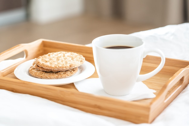 Dienblad met koffie en crackersontbijt op een bed