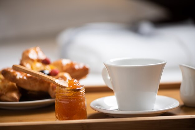 Dienblad met ontbijt op een bed in hotelkamer