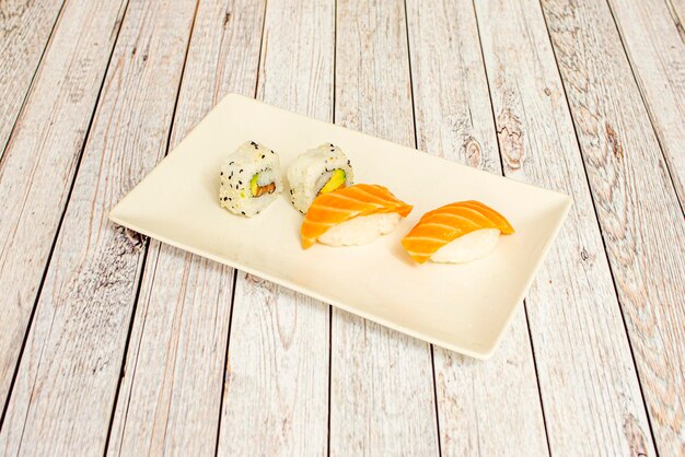 Dienblad zalm uramaki sushi en rijpe avocado en noorse zalm nigiri met witte rijst en japanse azijn