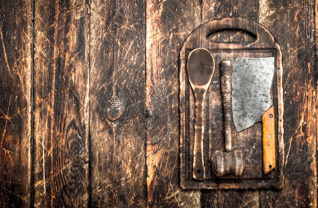 Dienende achtergrond. oude keukengereedschap snijplank. op een houten tafel.