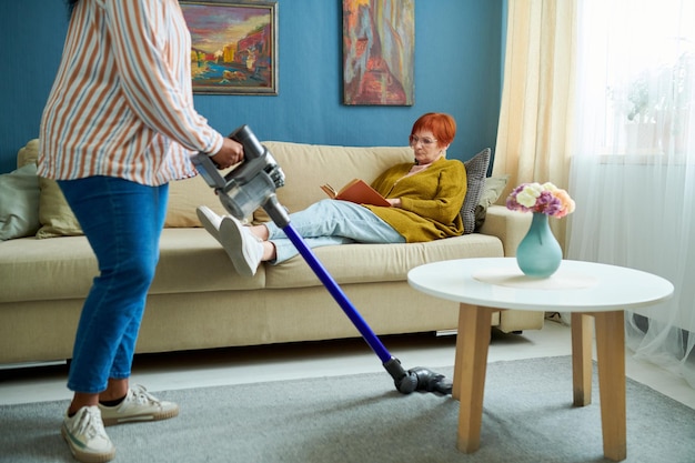 Dienstmeisje schoonmaak appartement van senior vrouw