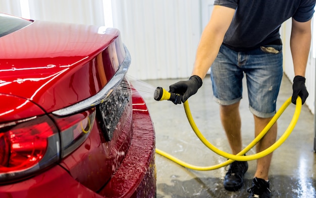 Dienstverlener auto wassen op een wasstraat.