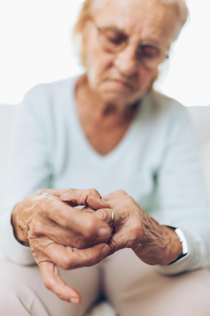 Diepbedroefde oudere vrouw die een trouwring vasthoudt