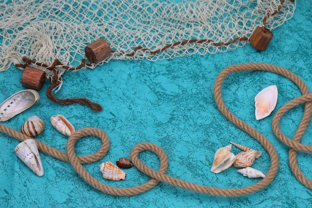 Diepblauwe achtergrond met schelpen, touw en visnet