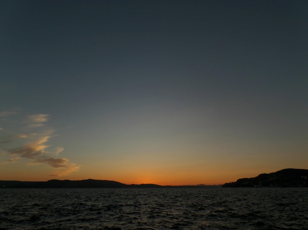 Diepblauwe en oranje Noorse zonsonderganghemel boven de Noordzee in Bergen, Noorwegen