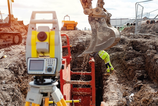 Diepe drainage graafwerkzaamheden met rode sleufsteunbox geïnstalleerd in de sleuf