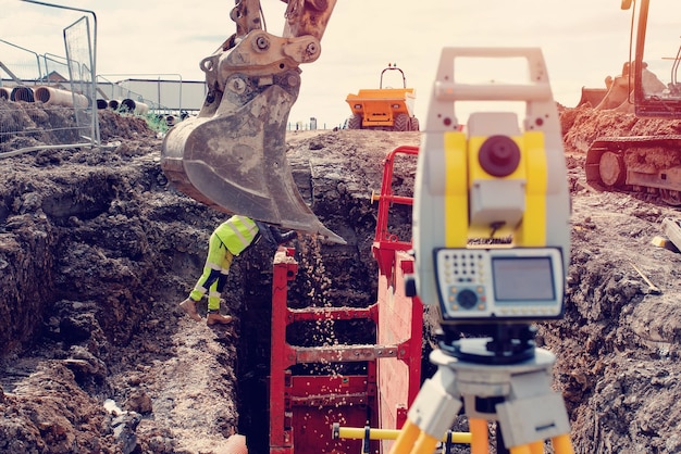 Diepe drainage graafwerkzaamheden met rode sleufsteunbox geïnstalleerd in de sleuf