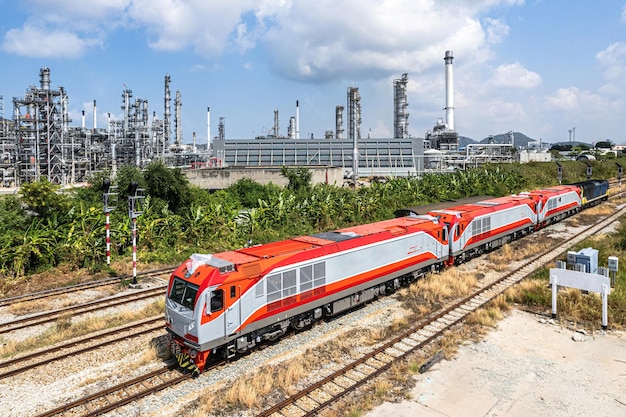 A dieselelectric locomotive passing by an oil refinery