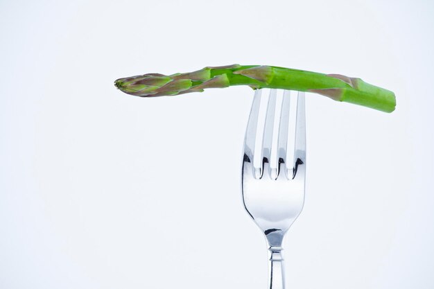 Foto dieta, morso di asparagi in una forchetta