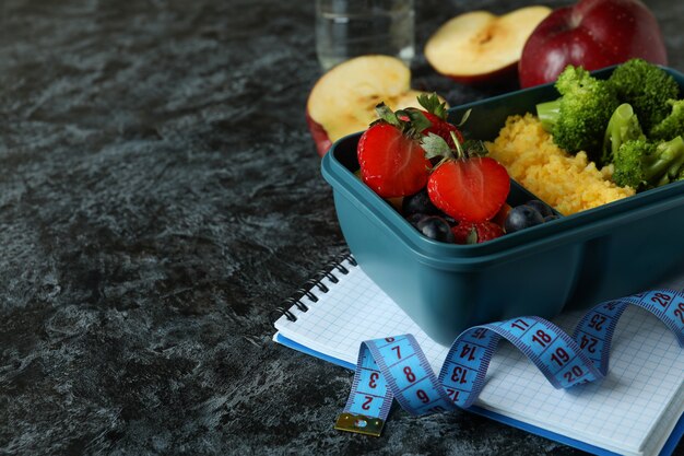 Diet concept with lunch box on black smokey table