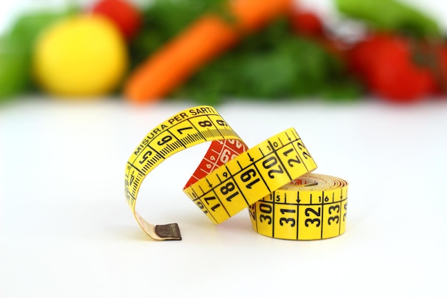 diet concept with measuring tape fresh vegetables on a white background Selective focus