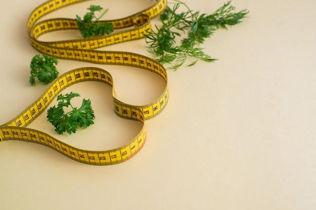 Diet concept on yelow background with measuring tape isolated