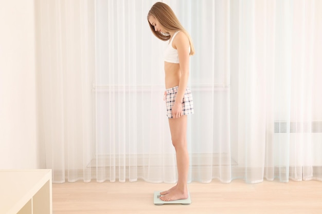 사진 다이어트 개념 저울에 서 있는 아름 다운 젊은 여자