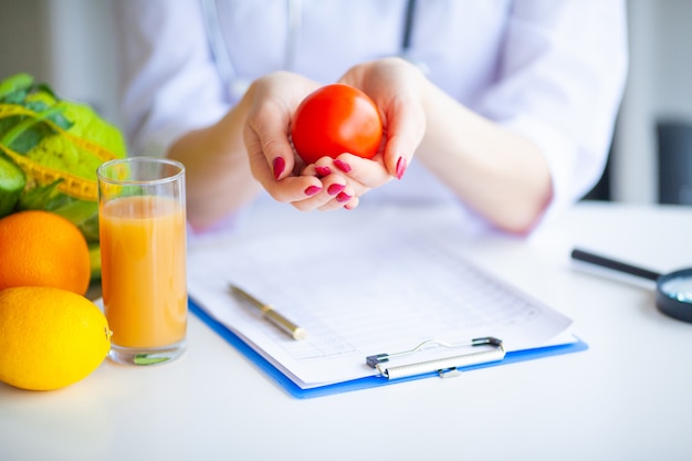 Dieta. doctor nutritionist tenere il pomodoro. concetto di cibo naturale e stile di vita sano. fitness e concetto di dieta alimentare sana. dieta equilibrata con verdure.