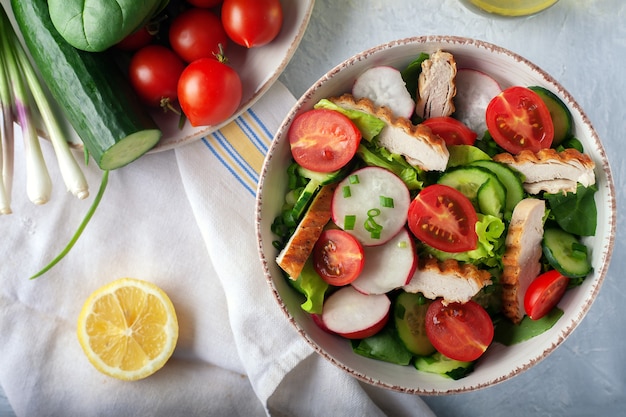 Diet food. Grilled chicken breast, fillet and fresh vegetable salad of lettuce, spinach, cucumber and tomato.