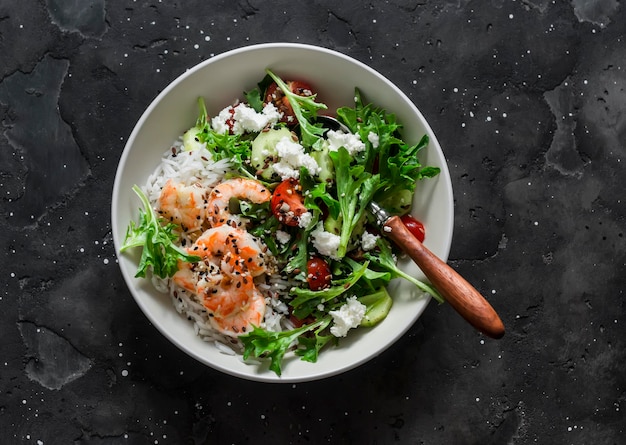 Diet healthy food concept lunch rice shrimp and fresh vegetable salad in one bowl on a dark background top view