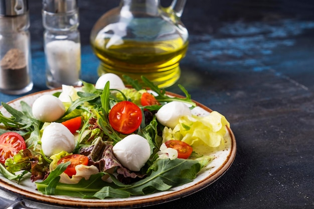 Photo diet and healthy salad with mozzarella cheese arugula lettuce and cherry tomatoes text space
