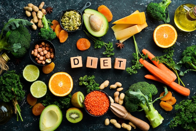 DIET inscription Avocado carrot orange broccoli dried fruits nuts and parsley Top view Free space for your text