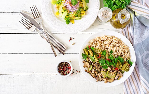 Diet menu. Healthy vegetarian meal - mushrooms shiitake, zucchini  and oatmeal porridge on bowl. Vegan food. Flat lay. Top view