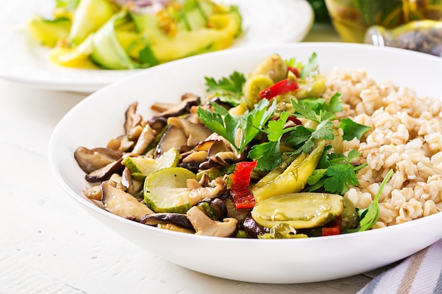 Diet menu. Healthy vegetarian meal - mushrooms shiitake, zucchini  and oatmeal porridge on bowl. Vegan food.