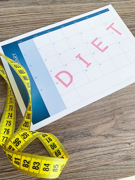 Diet plan concept Measuring tape and diet plan on wooden background