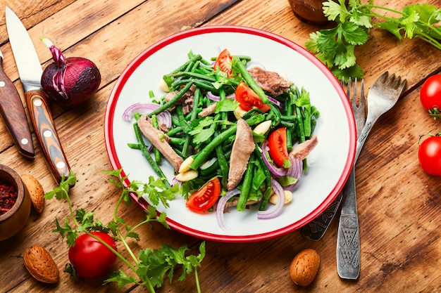 Диетический салат с телячьим языком, спаржей, помидорами, зеленью и миндалем.