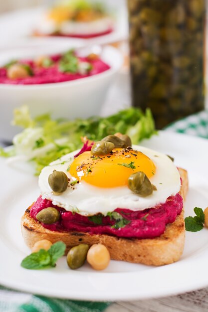 Diet sandwiches with beet root hummus, capers and egg