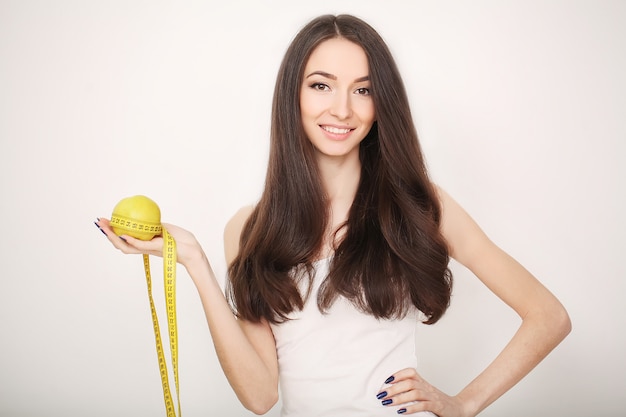 Diet, Slim young woman measuring her waist with a tape measure 