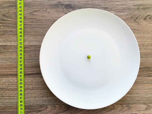 Diet suffering from anorexia cropped image pea on white plate