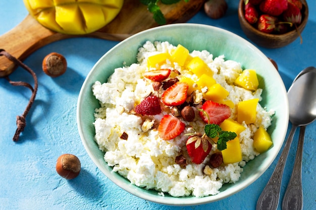 Dietary breakfast for summer time Fresh cottage cheese with strawberry mango and nuts