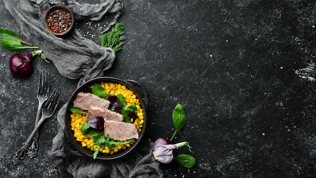 Dietary nutrition Boiled veal with corn and spinach in a black bowl Rustic style