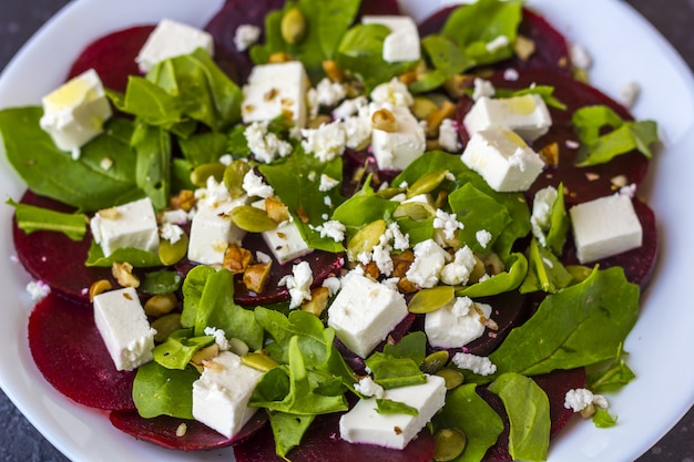 Dietary salad of beetroot, arugula, feta cheese, pumpkin seeds with olive oil 