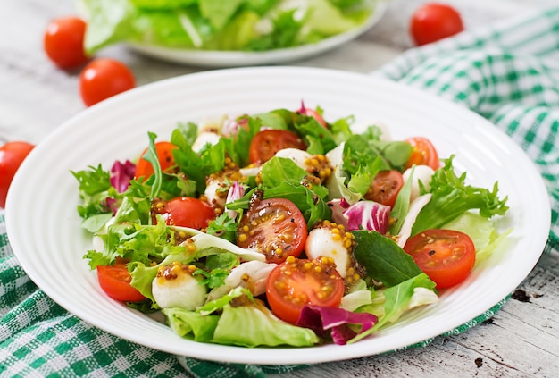 Dietary salad with tomatoes, mozzarella lettuce with honey-mustard dressing