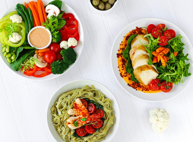 Foto insalate dietetiche a base di verdure fresche, frutti di mare e carne di pollo bianca