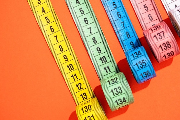 dieting concept colorful measuring tapes top view on bright red background flat lay pattern