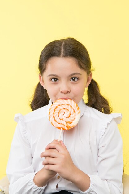 Dieting dieting and healthy food concept dieting after dessert eating small girl with lollipop doesn't like dieting healthy life