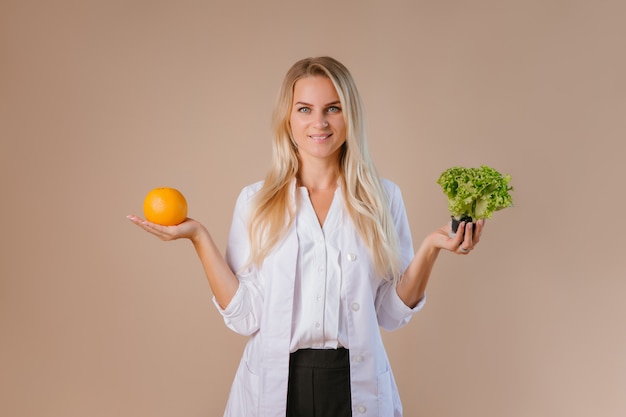 The dietitian is holding fruits and vegetables