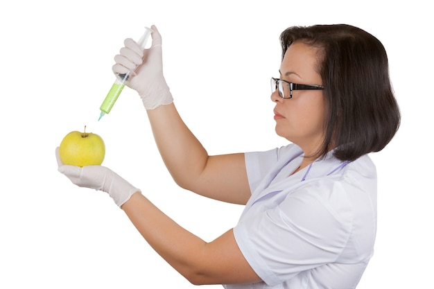 Foto scienziata dietista dottoressa che tiene mela verde fresca che viene iniettata con una siringa su bianco su sfondo bianco