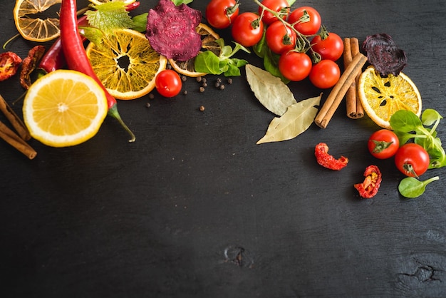 Differen vegetables food ingredients and spices on black background