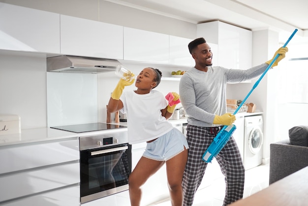 La differenza tra ordinario e straordinario è un piccolo scatto in più di una giovane coppia felice che si diverte mentre pulisce la cucina di casa