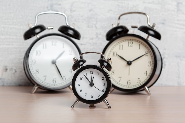 Different alarm clocks on table.