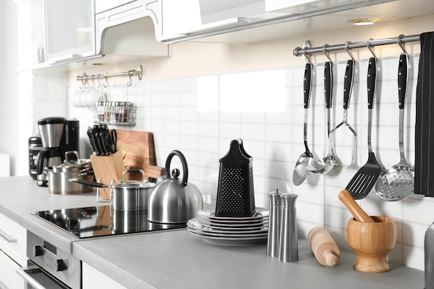 Photo different appliances clean dishes and utensils on kitchen counter