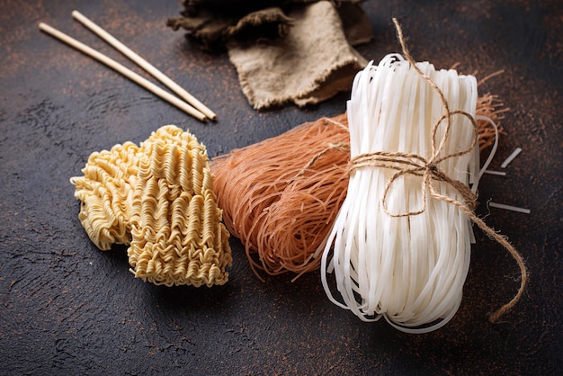 Different Asian rice noodles on rusty background