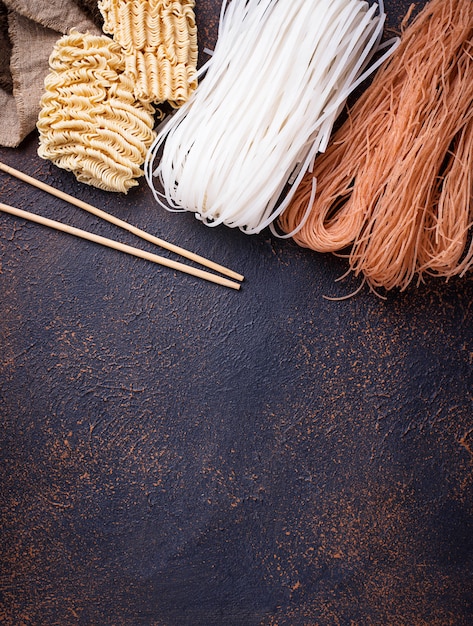 Different Asian rice noodles on rusty background