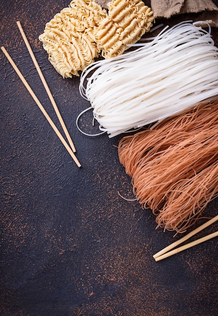 Different Asian rice noodles on rusty background