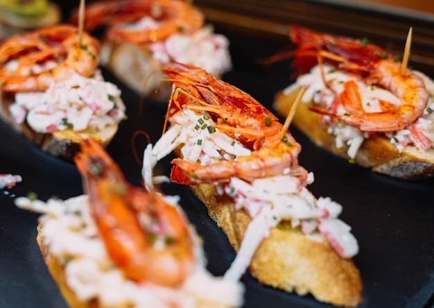 Different assorted canapes of bread with crab ham and vegetables